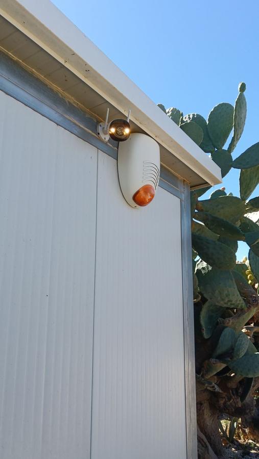 Sirena esterna autoalimentata e telecamera wireless installate sotto la gronda di un capannone